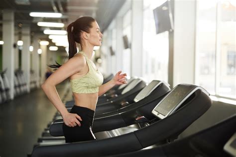 Mujer corriendo en caminadora en el gimnasio
