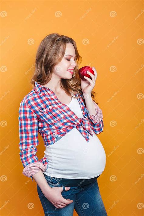 Mujer embarazada comiendo una manzana