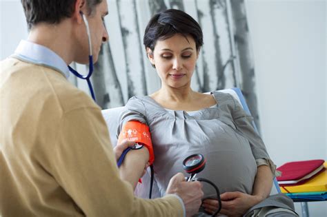 Mujer embarazada midiéndose la presión arterial